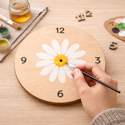 Hand painting a daisy on a round wooden clock face during DIY project
